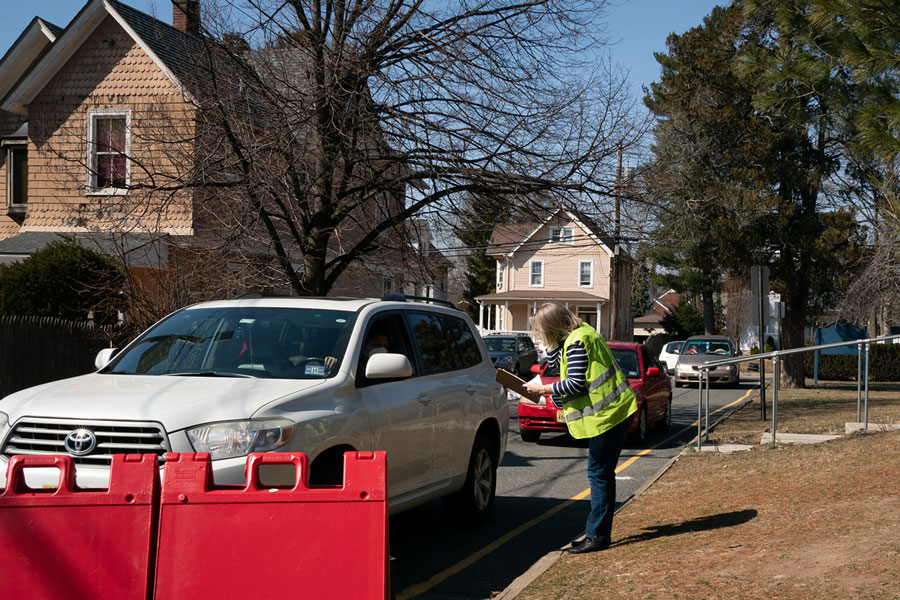 A volunteer collects information from drivers lined up to receive the food boxes.