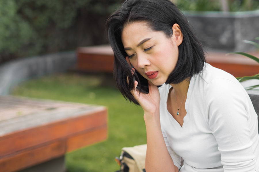 Asian woman have a serious phone conversation.