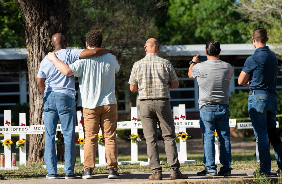 Community members at the Robb Elementary School memorial pray, visit, and leave tokens of affection at the crosses dedicated to the victims of the shooting. File photo: Jinitzail Hernandez, Shutter Stock, licensed.
