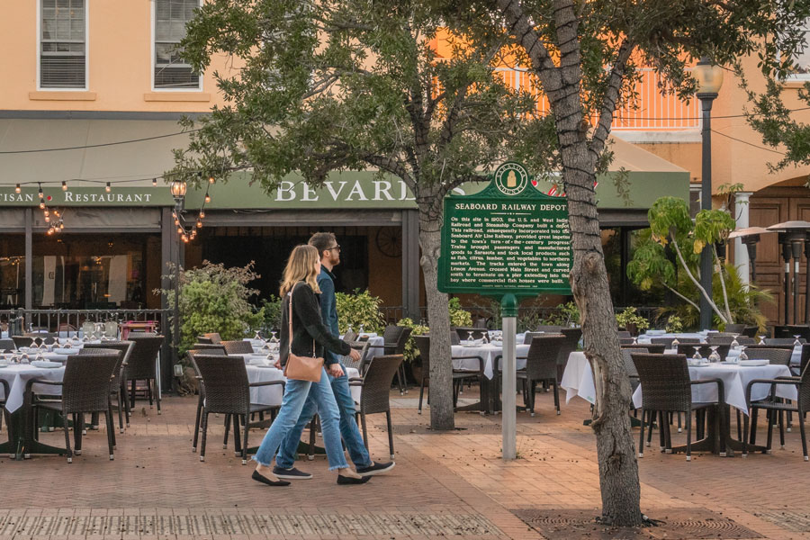 A young couple walk past restaurant with outdoor seating in the historic downtown district of city. File photo: Heidi Besen, Shutter Stock, licensed.